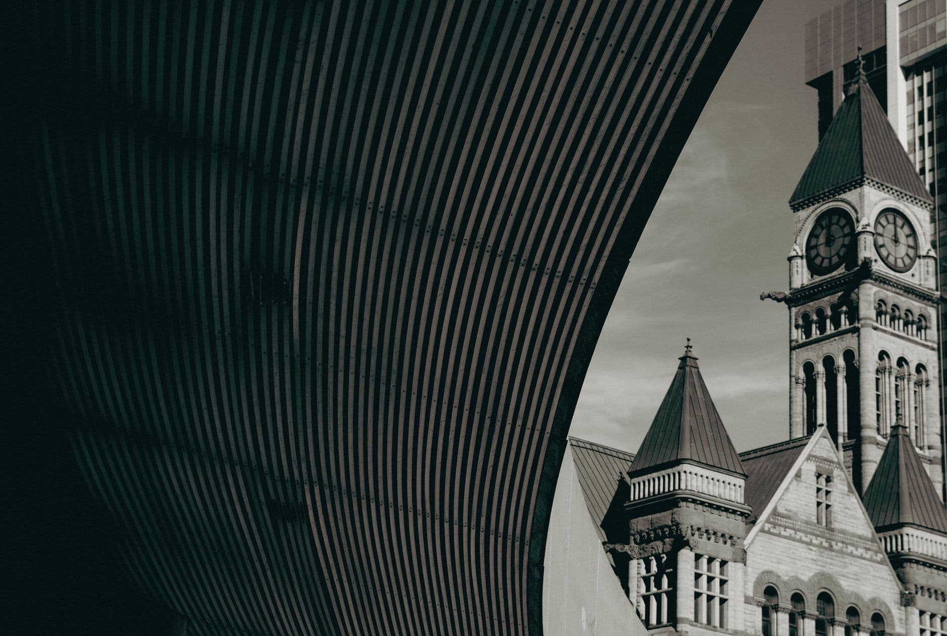 A vintage view of Toronto's Old City Hall tower with urban architecture.